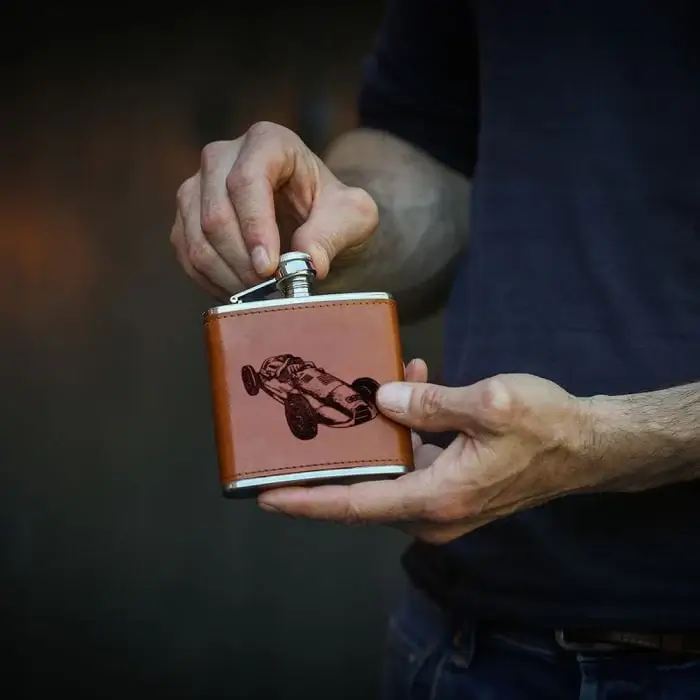 Heupflesje die door man wordt opengedraaid