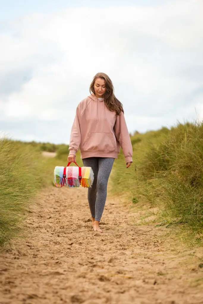 Vrouw met picknick kleed op het strand
